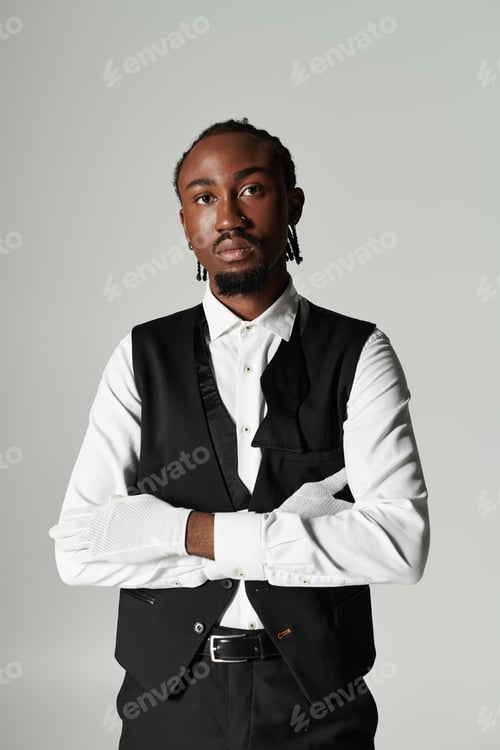 Preview: Young Black man in a stylish suit poses confidently on a grey background