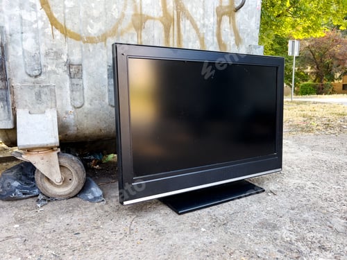 Preview: Old obsolete tv device by the trash container