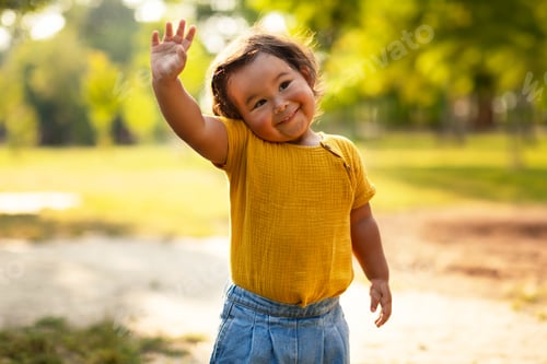 Preview: Adorable Little Baby Girl In Casual Waving Hand Standing Outdoor