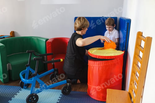 Preview: Young cute boy with cerebral palsy participates in a rehabilitation activity with physical