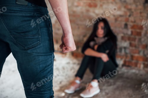 Preview: Violent man standing and threatens girl that sits on the floor with teddy bear in abandoned building
