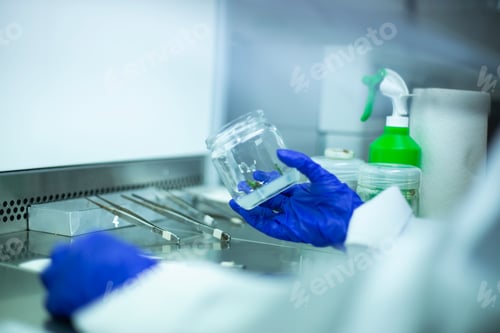 Preview: Scientist holding a glass jar with a plant specimen. Biology, research.