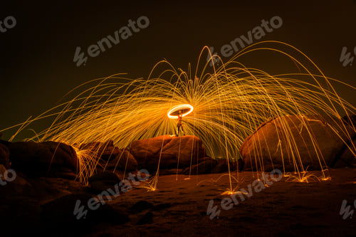 Preview: Fire dancing show swing lighting effects circle on bridge dark sky on night time.