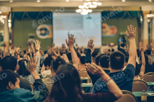 Preview: Rear view of Audience showing hand to answer the question from Speaker on the stage