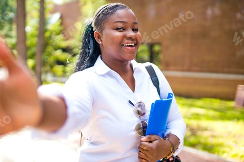 Preview: Beautiful smiling young african woman wearing white t-shirt and holding a copybook