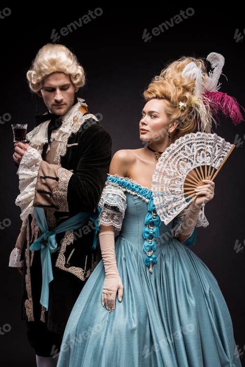 Preview: handsome man with wine glass near young victorian woman in wig holding fan on black