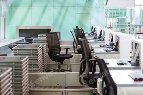 Preview: Row of check-in desks with computer monitors at empty airport terminal during covid-19 pandemic