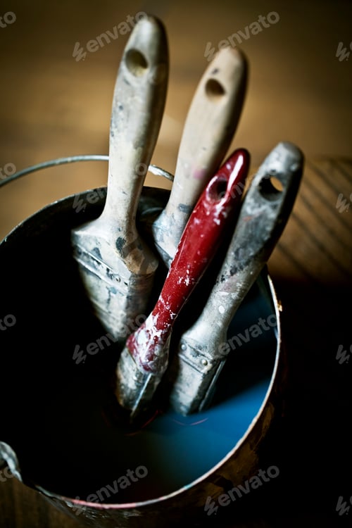 Preview: A collection of paintbrushes in liquid in a brush pail.