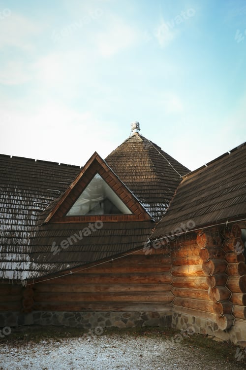 Preview: Cozy wooden house in winter day against blue sky