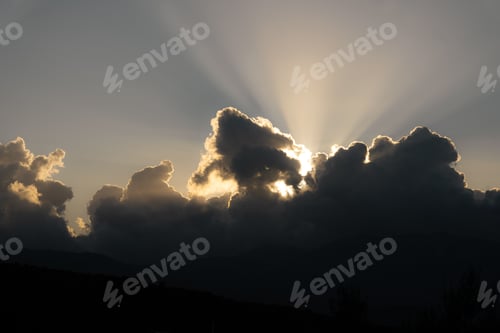 Preview: Sun rays through clouds and sunsets behind mountains