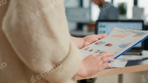 Preview: Closeup of woman hands holding clipboard with papers looking at pie chart and business profit data