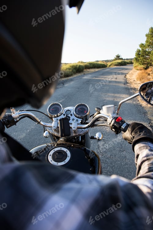 Preview: Back view of man riding motorbike on open road