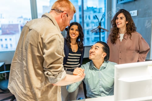 Preview: Managers shaking hands congratulating employee during a business meeting