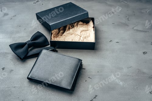 Preview: Black leather wallet and bow-tie on grey background