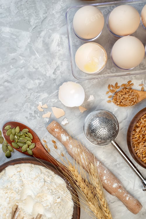 Preview: top view flour bowl eggs in viol wooden spoon rolling pin on table