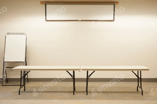 Preview: Empty tables under projector screen in classroom