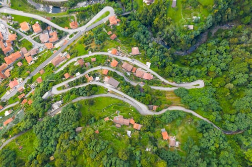 Preview: High angle view of houses with red roofs amoung trees on the top of the mountain in summer. Arial