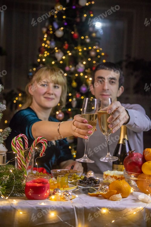 Preview: Champagne in hand against the background of the Christmas tree. People. Selective focus.
