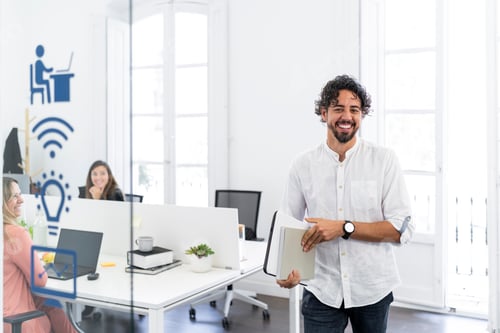 Preview: Smiling businessman holding documents standing in modern office with coworkers working