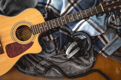Preview: Acoustic guitar, plaids and and headphones, top view.