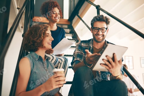 Preview: Shot of a group of designers using a digital tablet together in an office