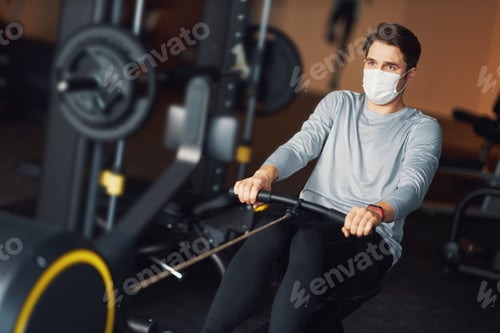 Preview: Adult man working out in a gym wearing mask