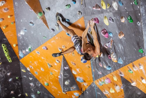 Preview: Young male rock climber in indoor climbing gym