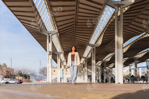 Preview: Woman walking urban station architecture on a sunny morning