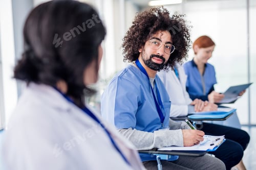 Preview: Group of doctors with tablet on medical conference, talking