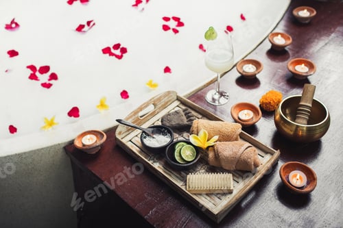 Preview: Romantic spa set with lime, scrub, salt, towels and brush in wooden tray. Flower petals in bath tub