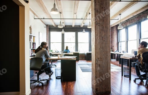 Visualização: Mulher asiática e homem hispânico trabalhando em suas mesas em um escritório criativo.