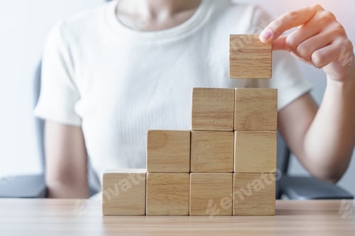 Preview: Woman hand placing wood block on the building