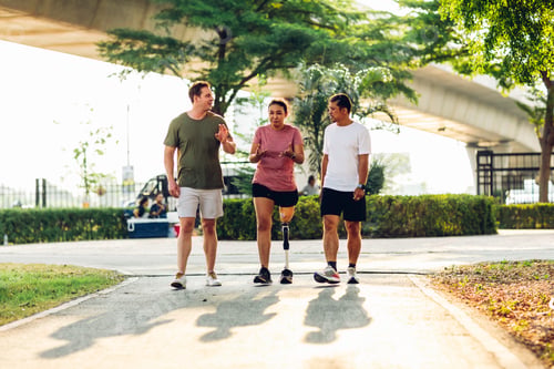 Preview: Friend support Friend with a prosthetic leg while exercising outdoor.