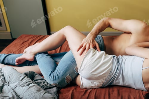 Preview: cropped view of passionate man hugging sexy girl in bedroom