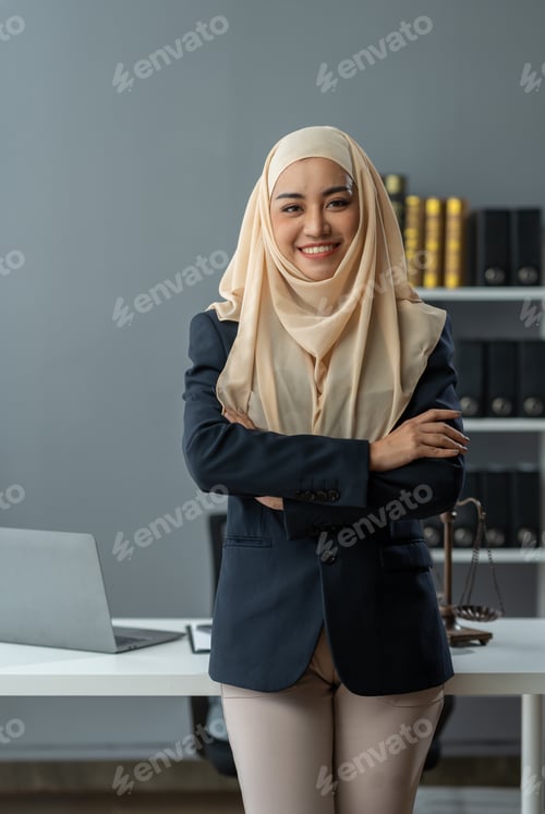 Preview: An Asian Muslim female lawyer wearing a hijab stands with her arms crossed. Confident smiling at wor