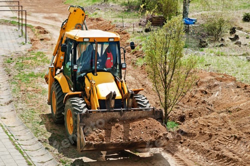 Preview: Tractor bucket levels a trench near the house
