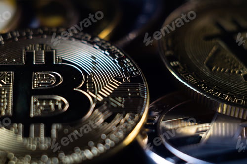 Preview: Closeup shot of silver bitcoins scattered on a surface illuminated with bright light
