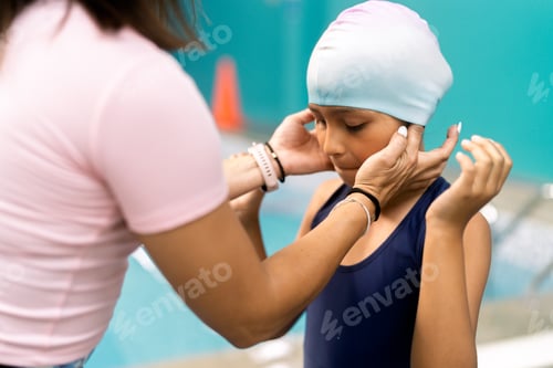 Preview: Instructor helping young girl preparing for swimming lesson