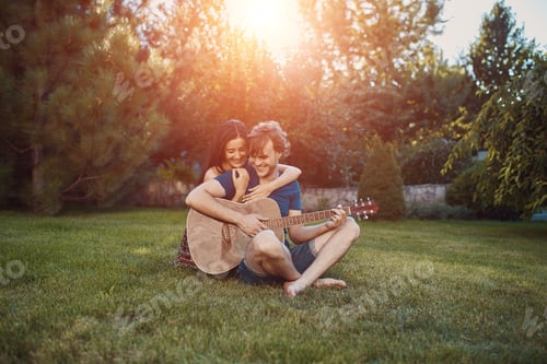 Preview: Romantic couple sitting on the grass in the garden