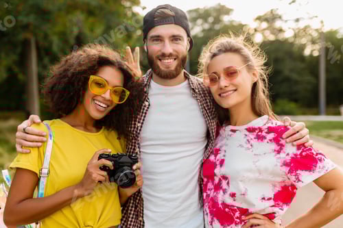 Preview: happy young company of emotional smiling friends walking in park