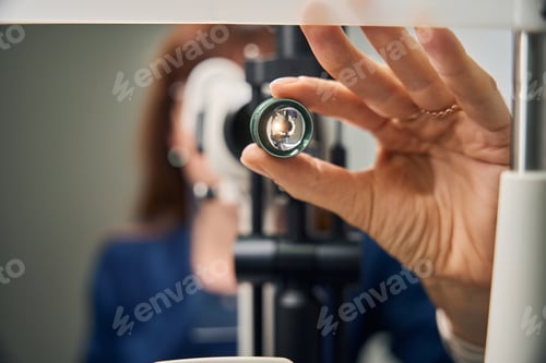 Preview: Optometrist adjusting slit lamp lens for examination