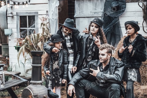 Preview: Scary family, mother, father, daughters celebrating halloween. Terrifying black skull half-face make