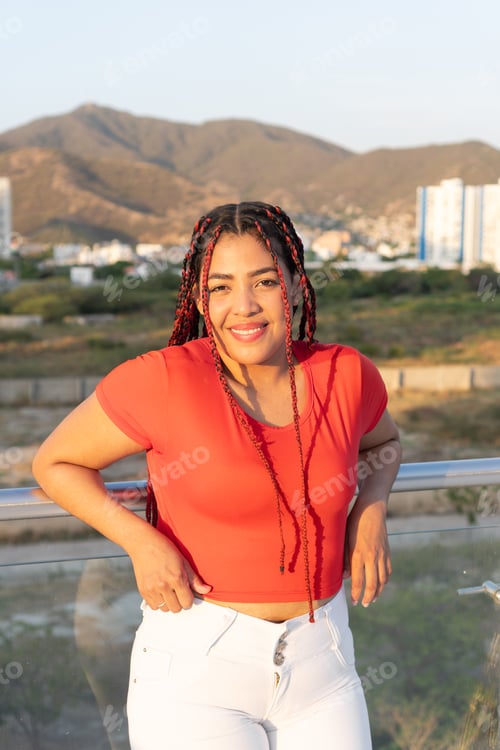Preview: Young woman leaning on railing enjoying city view with mountain landscape