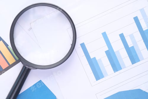 Preview: financial graph, magnifying glass on table