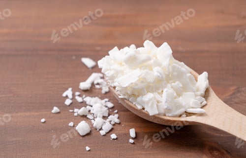 Preview: soy wax in wooden spoon on wooden background, copy space
