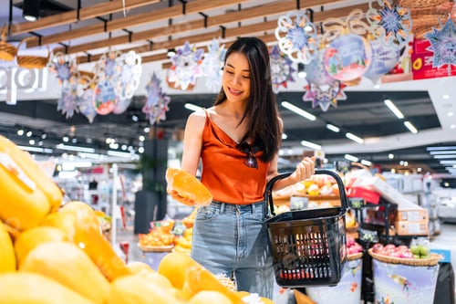 Preview: Asian young beautiful woman holding grocery basket walk in supermarket.