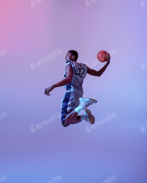Preview: Basketball player jumping with ball in studio