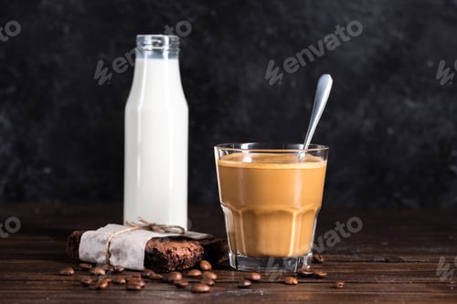 Preview: coffee, milk in glass bottle and homemade brownie cake on wooden tabletop