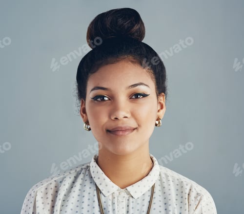 Preview: Quietly confident. Studio portrait of an attractive young woman posing against a gray background.