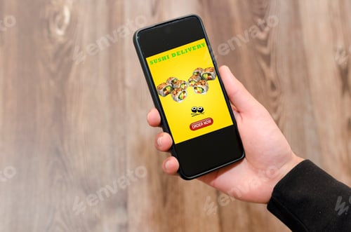 Preview: Man choosing a meal on food delivery app. Sushi, japanese food.